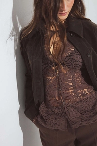 Detailed view of vintage brown lace texture and corduroy fabric on a women's jacket