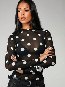 Close-up of semi-transparent black mesh fabric with white polka dots and long sleeves
