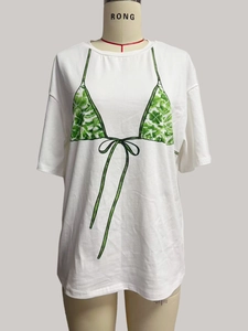 Détail d'un t-shirt blanc ample avec imprimé bikini créatif aux motifs de feuilles