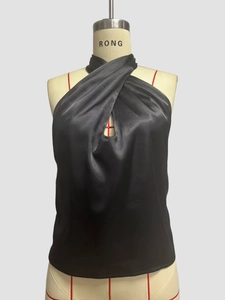 Close-up of black satin halter top with cross-neck design and teardrop cutout detail