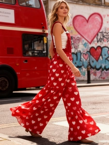 Detail eines roten Jumpsuits mit weißen Herzprints und gestuften Rüschen am weiten Bein