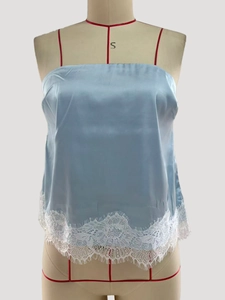 Detail of light blue satin camisole featuring delicate white eyelash lace hem