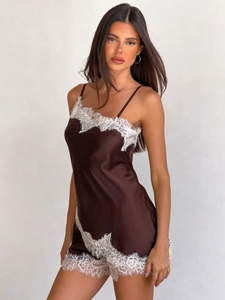 Dettaglio della lingerie in raso marrone scuro con pizzo bianco e spalline sottili