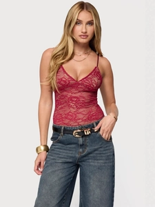 Elegant red lace bustier top with floral patterns paired with high-waist jeans on a model