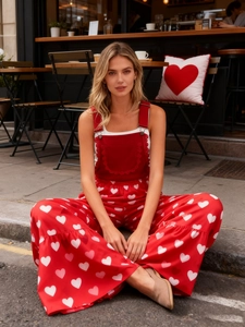 Detail der roten Hose mit hohem Bund, weitem Bein, weißem Herzprint und Spitzenbesatz