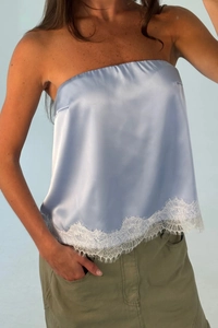 Detail of light blue satin tube top featuring delicate white lace trim and silky texture