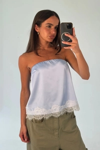 Close-up of light blue satin tube top featuring delicate white floral lace trim detailing