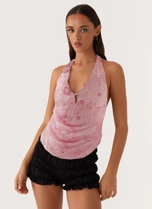 Détail du haut dos nu à fleurs à paillettes roses et short noir à volants