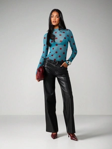 Full view of blue mesh polka dot top paired with black leather pants and red studded heels