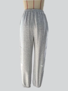 Detail view of grey casual joggers featuring white star patches and ribbed cuffs