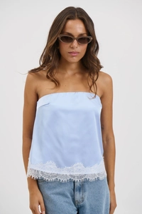 Macro shot of light blue satin tube top featuring delicate white floral lace trim detail