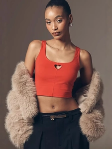 Slim fit red crop top with heart cutout paired with faux fur coat and high waist pants