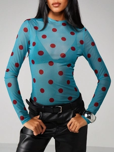 Detail of sheer mesh long sleeve top with blue fabric and red polka dot pattern