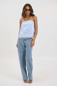 Detailed close-up of light blue satin tube top with delicate white lace hem trim