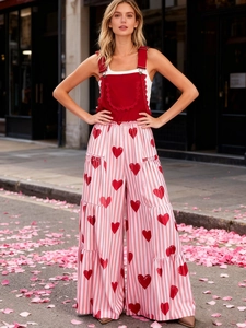 Detail von rotem Trägertop mit Rüschen und rosa gestreifter weiter Hose mit Herzprint