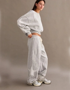 Detail view of grey joggers showing contrast star patchwork and soft cotton fabric texture