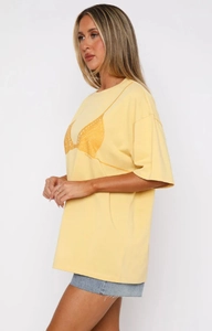 Détail du t-shirt ample en coton jaune pâle avec graphique bikini et logo
