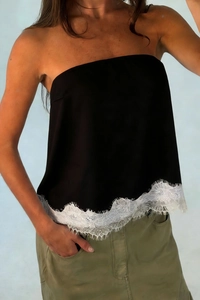 Detail of elegant black tube top featuring wide white eyelash lace trim on the hemline