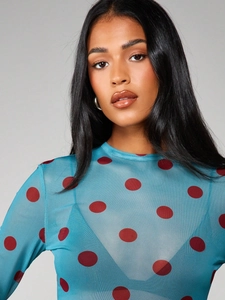 Detail view of sheer blue mesh top with red polka dots and soft crew neckline texture