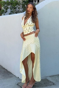 Detailansicht von gelbem Polka-Dot-Crop-Top und asymmetrischem Rock mit Rüschen