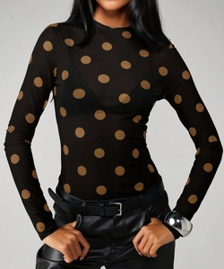 Detail of sheer mesh fabric texture on black long sleeve top with brown polka dot pattern
