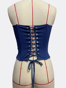 Detailed back view of deep blue corset top with criss-cross lace-up and metal eyelets