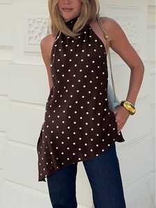 Detail of satin halter neck polka dot top with asymmetric hem and smooth texture