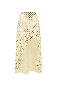 Detail eines gelben Polka-Dot-Rocks mit asymmetrischem Rüschensaum und fließendem Stoff