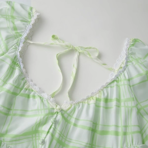Dettaglio dell'abito scozzese con bordo in pizzo sullo scollo e fiocco decorativo