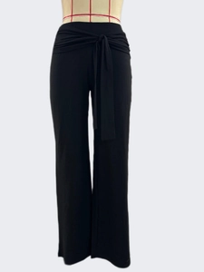 Detail of high waisted black wide leg trousers with waist tie and pleated design