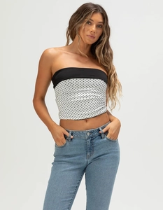 Detail view of a slim-fit tube top with classic black and white polka dot pattern design