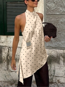 Detail of elegant champagne satin halter top with black polka dots and irregular hemline