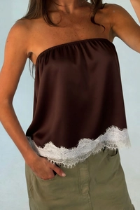 Detail of brown satin tube top featuring delicate white eyelash lace hem decoration