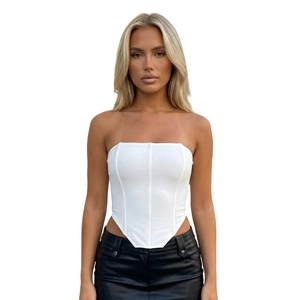 Detailed view of white corset top with boning structure and asymmetrical pointed hemline