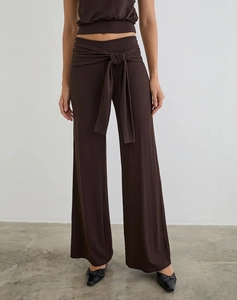 Detailed view of dark brown high-waisted wide-leg pants with a waist tie knot and fabric texture