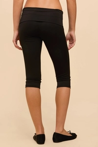 Close-up back view of women's black cropped leggings showing the slim fit and elastic fabric