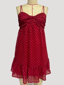 Close-up of red polka dot dress featuring a V-neck knot and ruffled chiffon hem