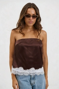 Detailed close-up of dark brown satin tube top with delicate white lace trim and eyelash edges