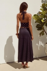 Detailansicht der Rückseite eines schwarzen Polka-Dot-Zweiteilers mit Neckholder-Top und Rock