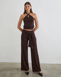 Detail view of dark brown halter neck top with teardrop cutout and wide-leg trousers