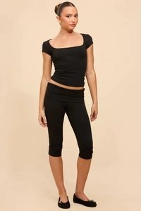 Detail view of black slim-fit two-piece workout set with U-neck top and cropped leggings