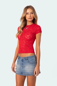 Detailed close-up of vibrant red lace fabric and intricate floral pattern on a slim-fit top