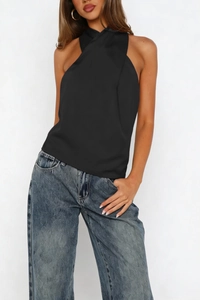 Detail of elegant black satin halter neck top showing smooth texture and draped design