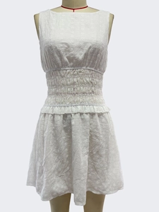 Close-up of white sleeveless mini dress with floral eyelet embroidery and smocked waist