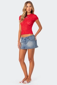 Detail of red hollow lace top with slim fit design and blue denim mini skirt