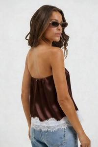Detail of dark brown satin tube top featuring elegant white floral lace hem trim