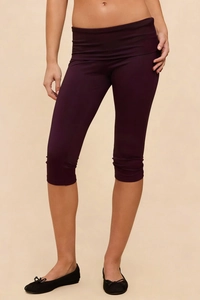 Detail of high-waisted dark purple capri yoga leggings with fold-over waistband design