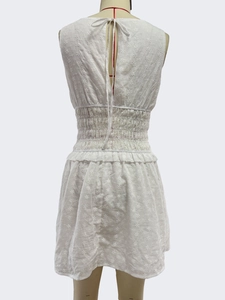 Detail of white eyelet embroidery and smocked waist on sleeveless summer dress
