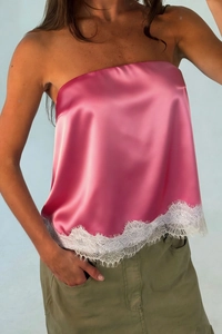 Detail of hot pink satin bandeau top featuring delicate white eyelash lace hem decoration