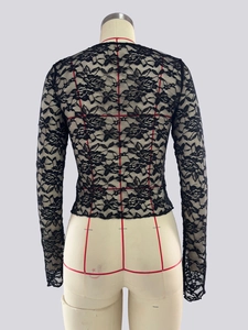 Close-up of elegant floral lace texture and transparent mesh on this slim black top